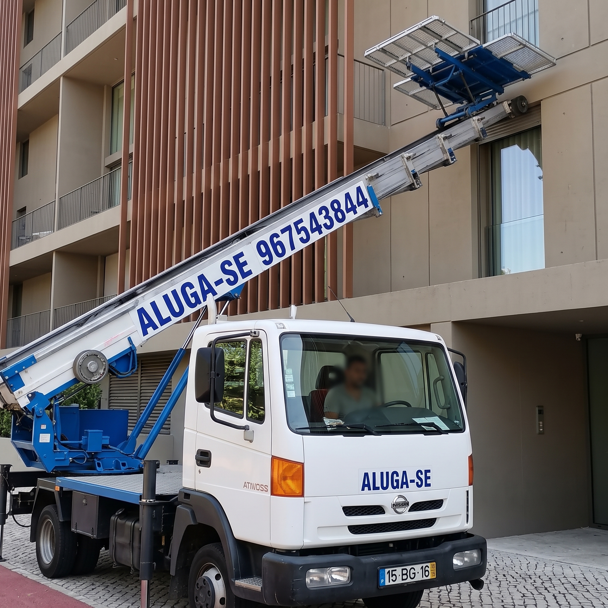 Caminhão com plataforma elevatória junto a um edifício